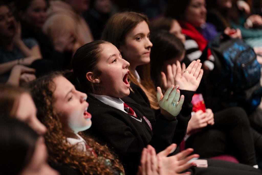 Children in audience, clapping and singing